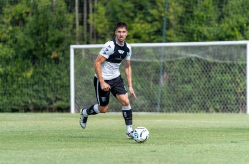 Soccer player dribbling the ball during practice outdoors on a sunny day.