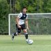 Soccer player dribbling the ball during practice outdoors on a sunny day.
